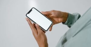 Mãos de uma pessoa segurando um celular com a tela em branco