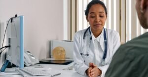 Médica com estetoscópio no pescoço conversa com paciente em consultório de atendimento clínico
