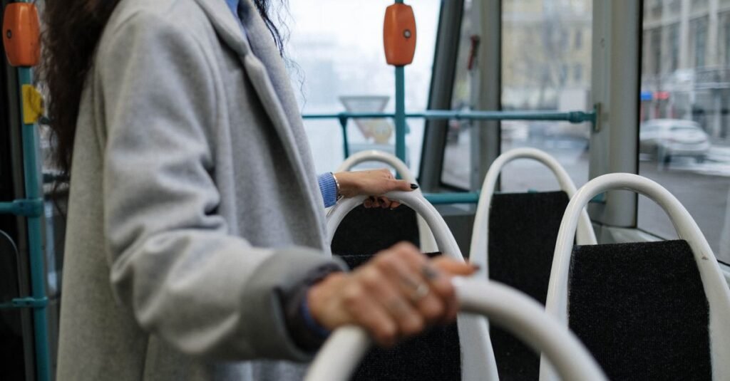 Passageira segura o corrimão dentro de um ônibus do transporte público urbano
