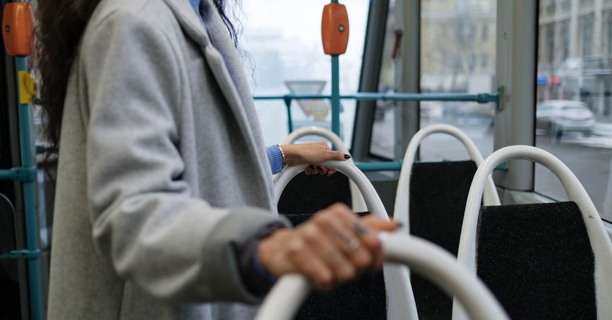 Passageira segura o corrimão dentro de um ônibus do transporte público urbano