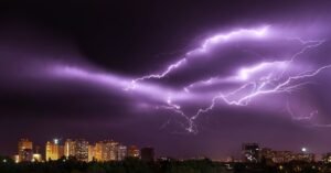 Raios cortam o céu à noite sobre uma área urbana com prédios iluminados