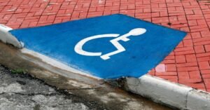 Rampa de acessibilidade em calçada com símbolo internacional de acesso pintado em azul