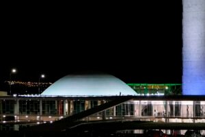 Cúpula do plenário do Senado iluminada à noite no conjunto do Congresso Nacional, em Brasília