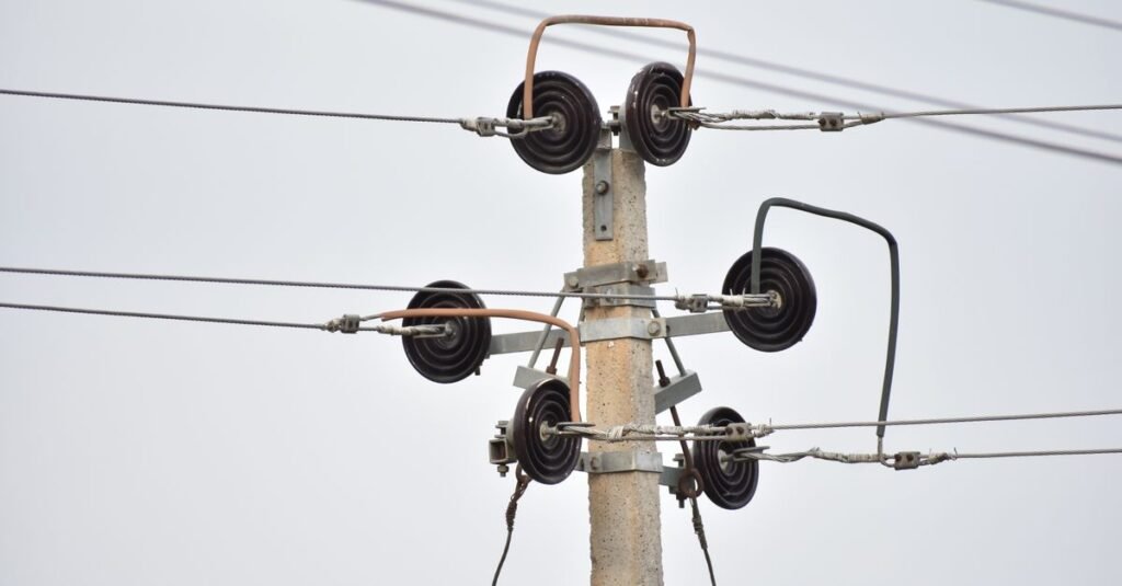 Poste de concreto com isoladores e fios da rede de distribuição de energia elétrica