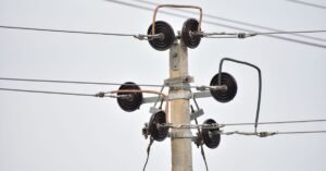 Poste de concreto com isoladores e fios da rede de distribuição de energia elétrica