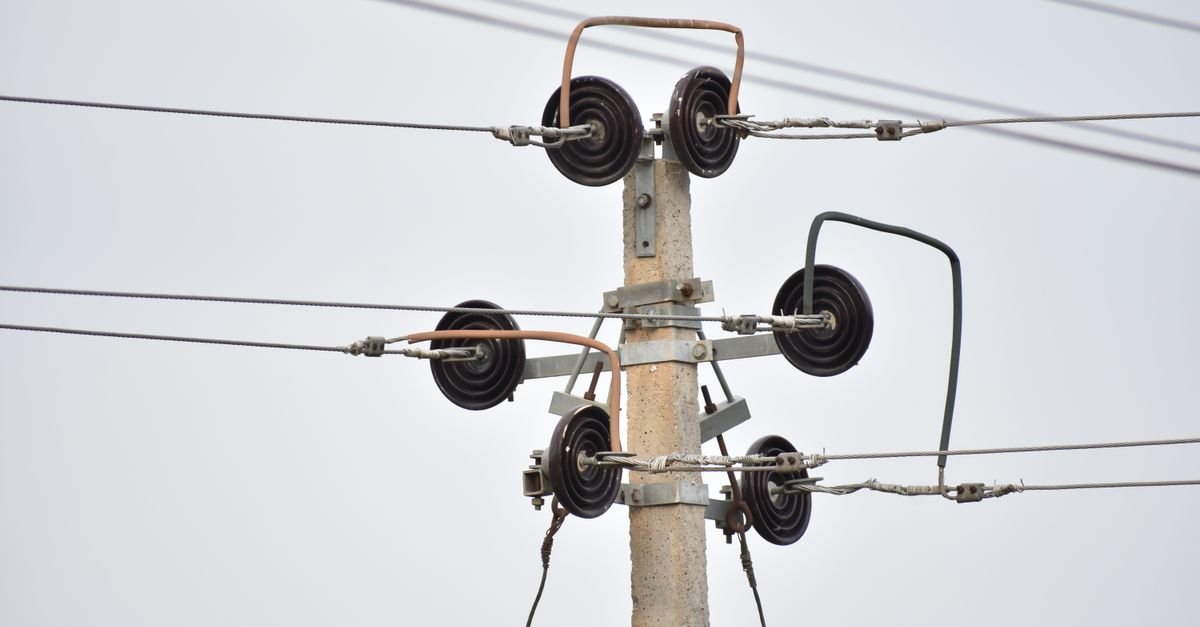 Poste de concreto com isoladores e fios da rede de distribuição de energia elétrica