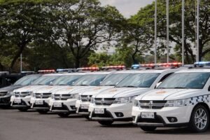 Fila de viaturas da Polícia Militar do Distrito Federal estacionadas com giroflex ligado