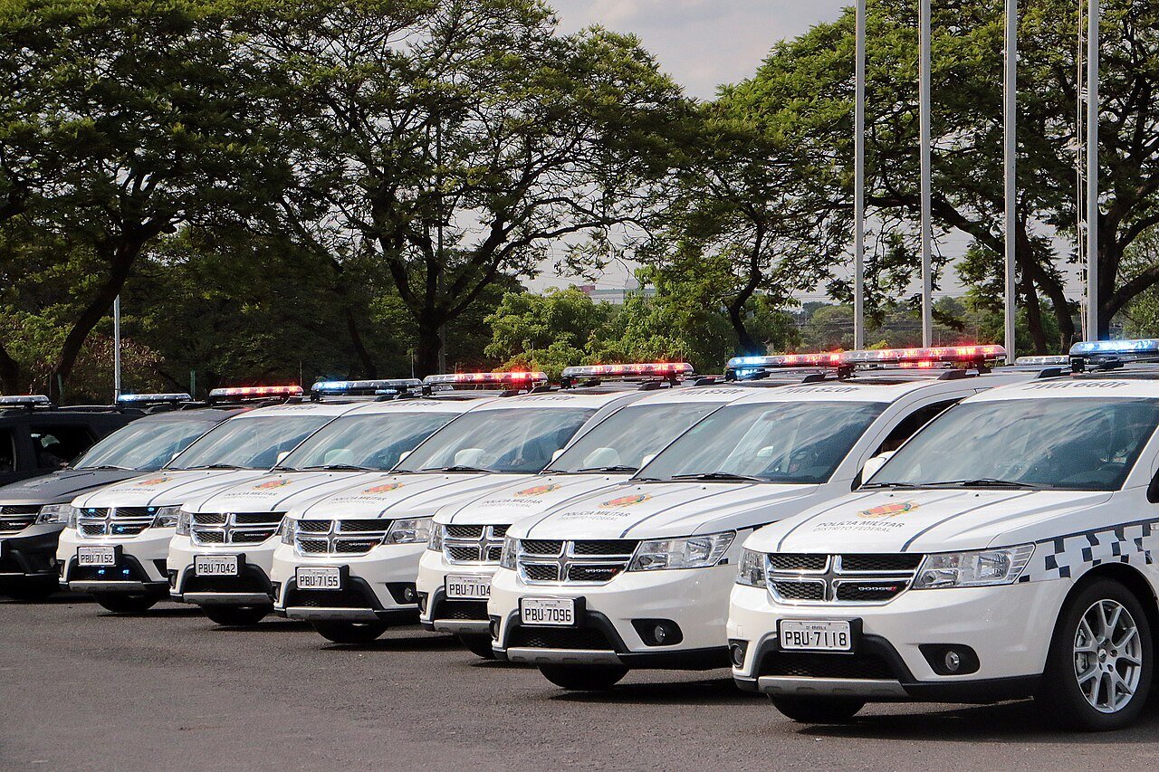 Fila de viaturas da Polícia Militar do Distrito Federal estacionadas com giroflex ligado