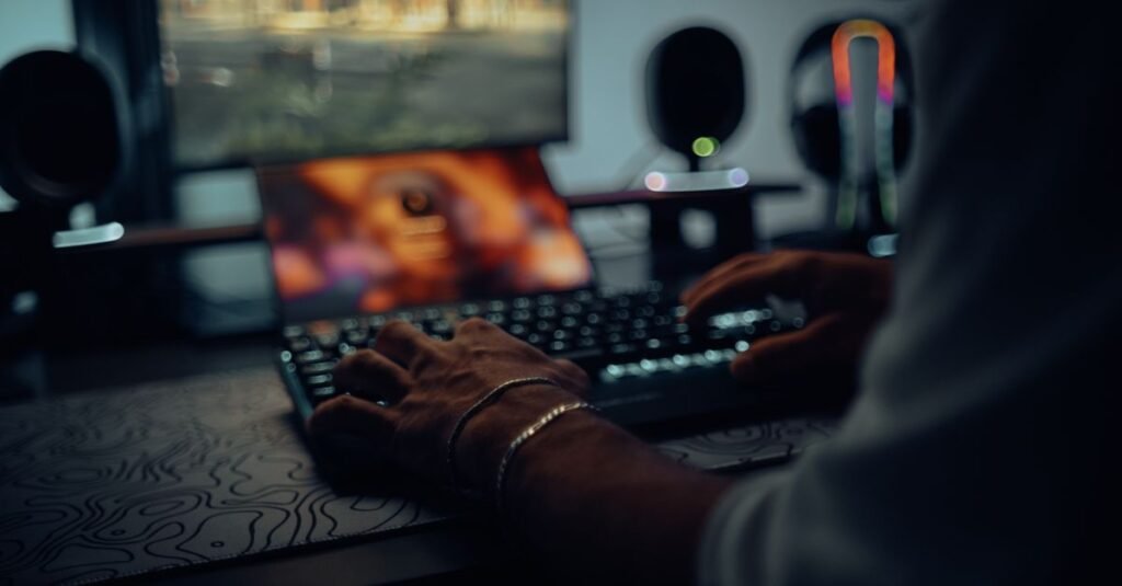 Mãos digitando em teclado de computador em ambiente escuro