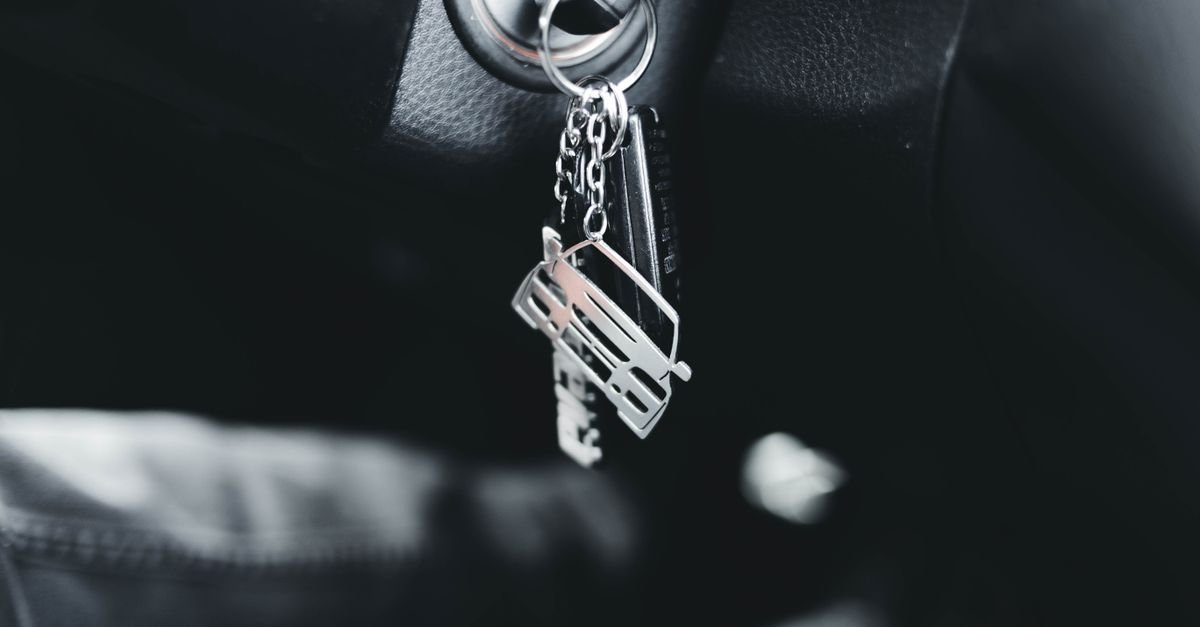Chave de carro na ignição, em close, dentro de veículo