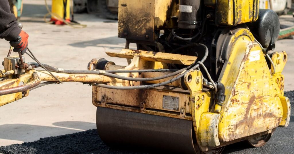 Rolo compactador aplicando asfalto em obra de pavimentação