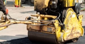 Rolo compactador aplicando asfalto em obra de pavimentação