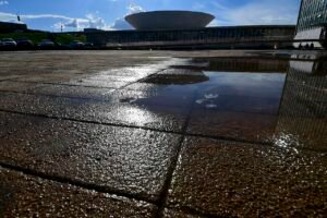 Fachada do Congresso Nacional refletida em poça d'água na Esplanada
