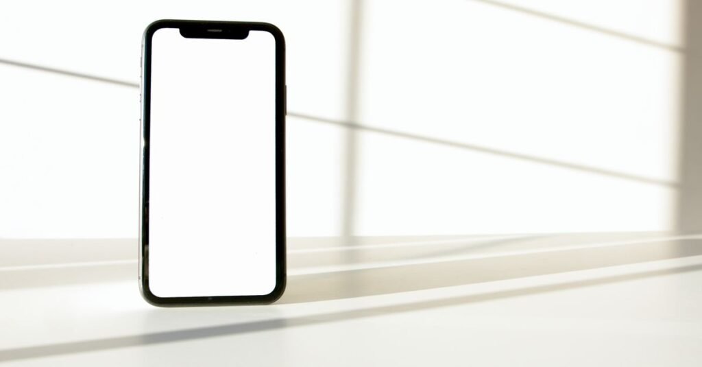 Celular com tela em branco apoiado sobre superfície clara