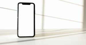 Celular com tela em branco apoiado sobre superfície clara
