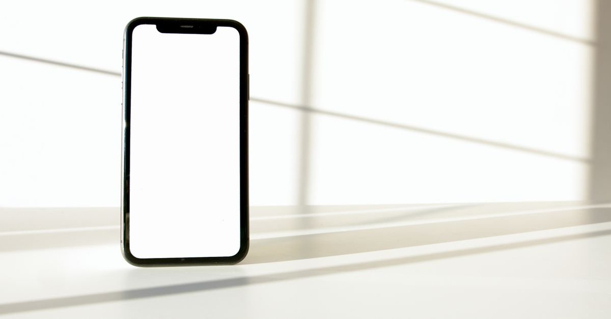 Celular com tela em branco apoiado sobre superfície clara