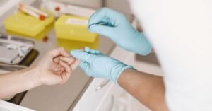 Profissional de saúde com luvas realiza coleta de sangue em paciente