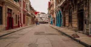 Rua do centro histórico de Havana, em Cuba, com casario colonial e um carro antigo ao fundo