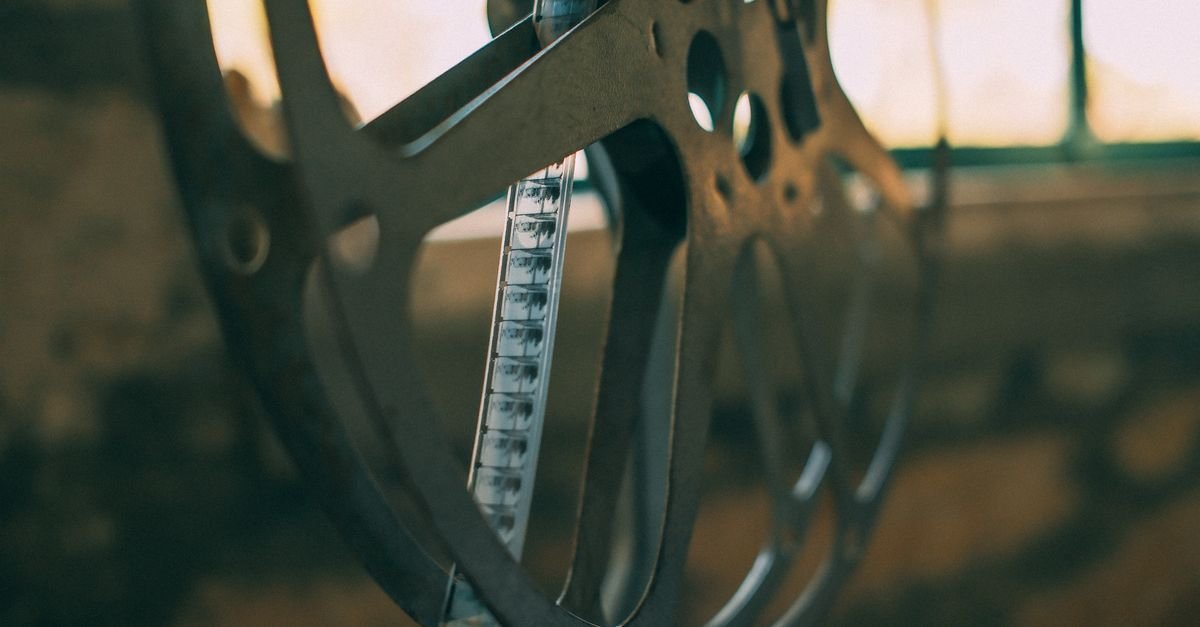 Rolo de filme cinematográfico em closeup, com a película exposta contra a luz