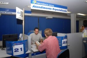 Balcao de atendimento da Previdencia Social com painel escrito Atendimento Especializado e guiches numerados