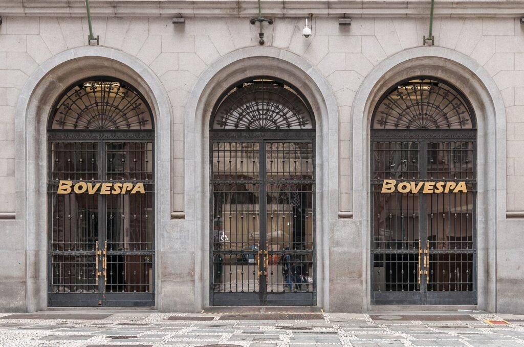 Fachada de pedra do prédio da Bovespa, no centro de São Paulo, com portas em arco e letreiro dourado