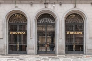 Fachada de pedra do prédio da Bovespa, no centro de São Paulo, com portas em arco e letreiro dourado