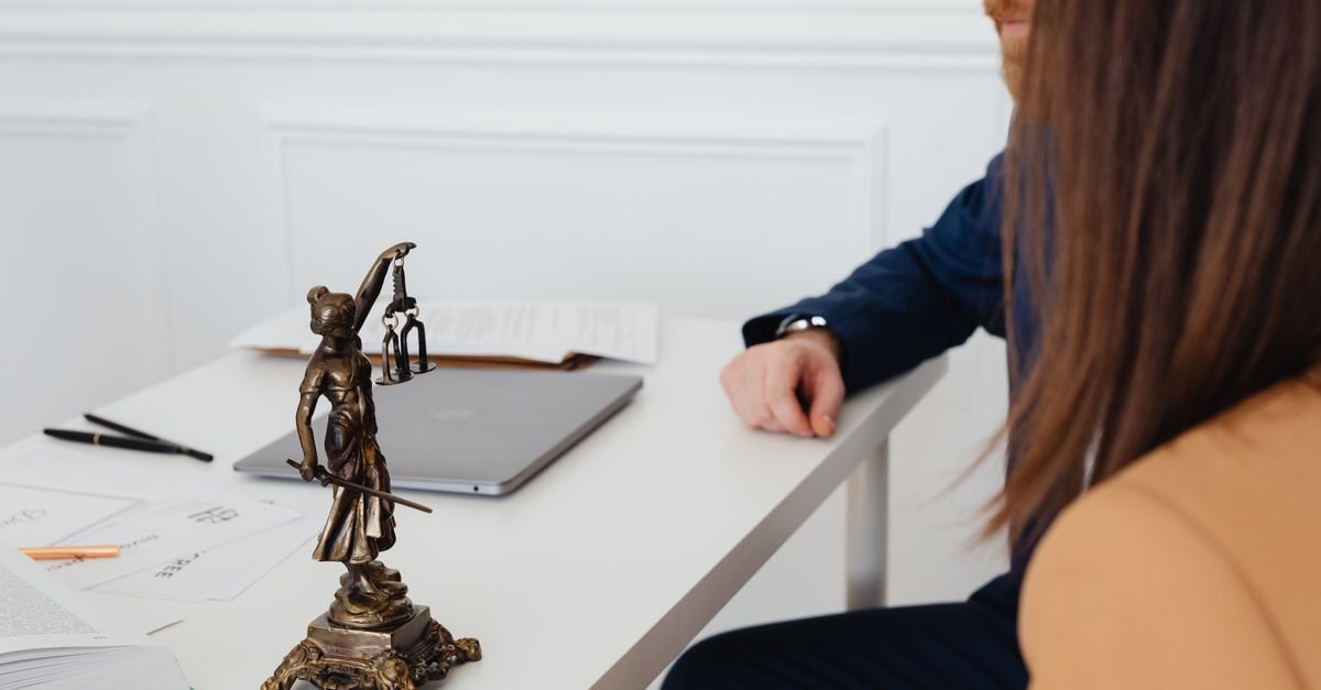 Estatueta da Justica sobre mesa de escritorio de advocacia