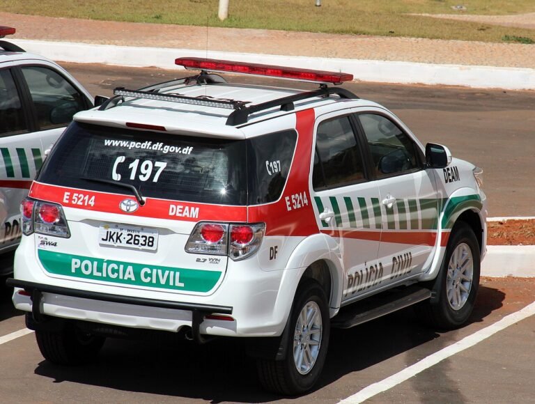 Viatura branca da Polícia Civil do Distrito Federal estacionada, com identificação da corporação e telefone 197 na traseira