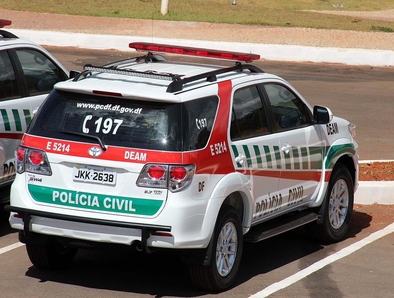 Viatura branca da Polícia Civil do Distrito Federal estacionada, com identificação da corporação e telefone 197 na traseira