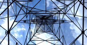 Torre de transmissão de energia elétrica vista de baixo contra o céu azul
