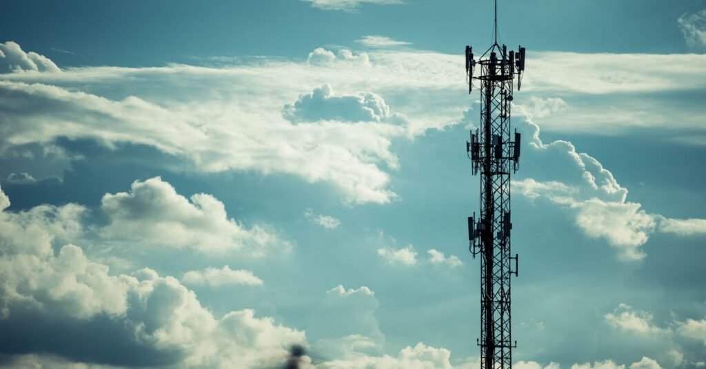 Silhueta de torre de telecomunicações com antenas contra céu nublado