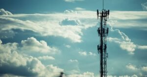 Silhueta de torre de telecomunicações com antenas contra céu nublado