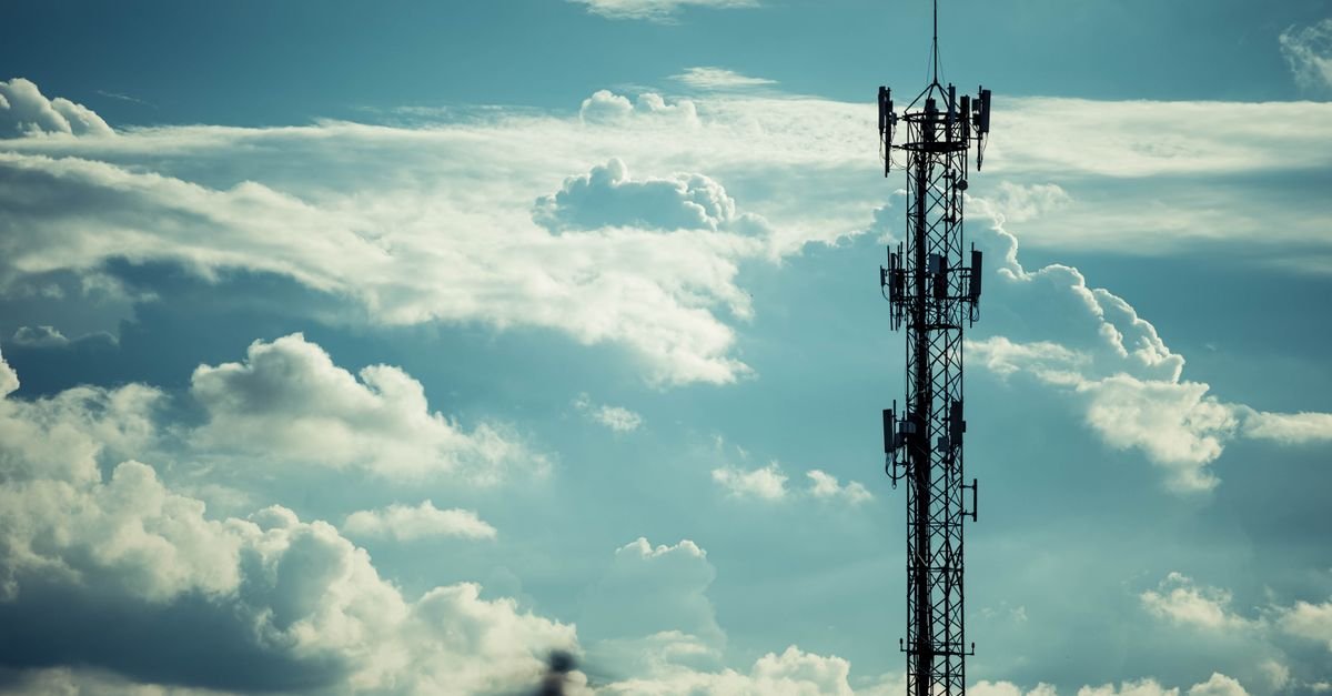 Silhueta de torre de telecomunicações com antenas contra céu nublado