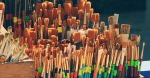 Grande quantidade de pincéis de pintura de vários tamanhos organizados em suportes de madeira