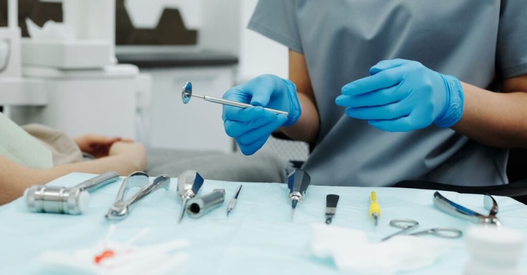 Profissional de odontologia com luvas organiza instrumentos odontológicos sobre mesa clínica