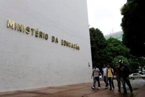 Fachada do prédio do Ministério da Educação, em Brasília, com o letreiro em letras douradas e estudantes caminhando na calçada