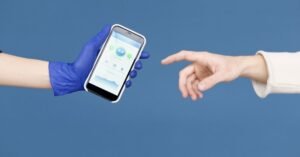 Mão entrega um celular com aplicativo de saúde na tela para outra pessoa, em fundo azul