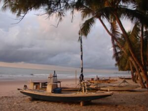 Jangadas na areia da praia de Boa Viagem, em Recife, com o mar ao fundo e céu nublado