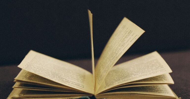 Livro antigo aberto com as páginas em meio a um movimento de virada