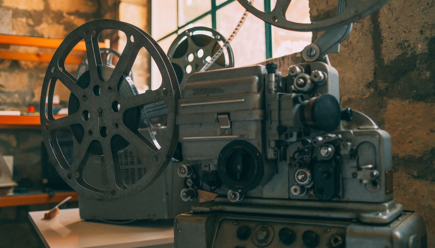 Projetor de cinema antigo com rolos de filme montados, em close-up