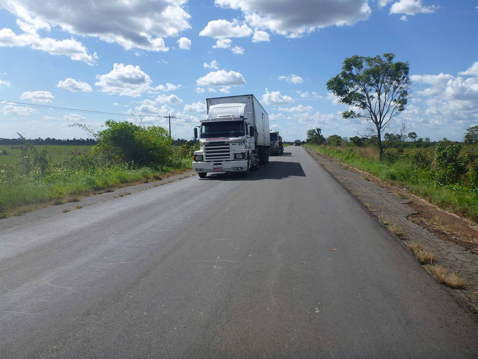 Caminhões trafegam pela BR-135, no Maranhão, em pista de mão dupla cercada por vegetação