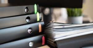 Pastas de processos empilhadas sobre mesa de escritório