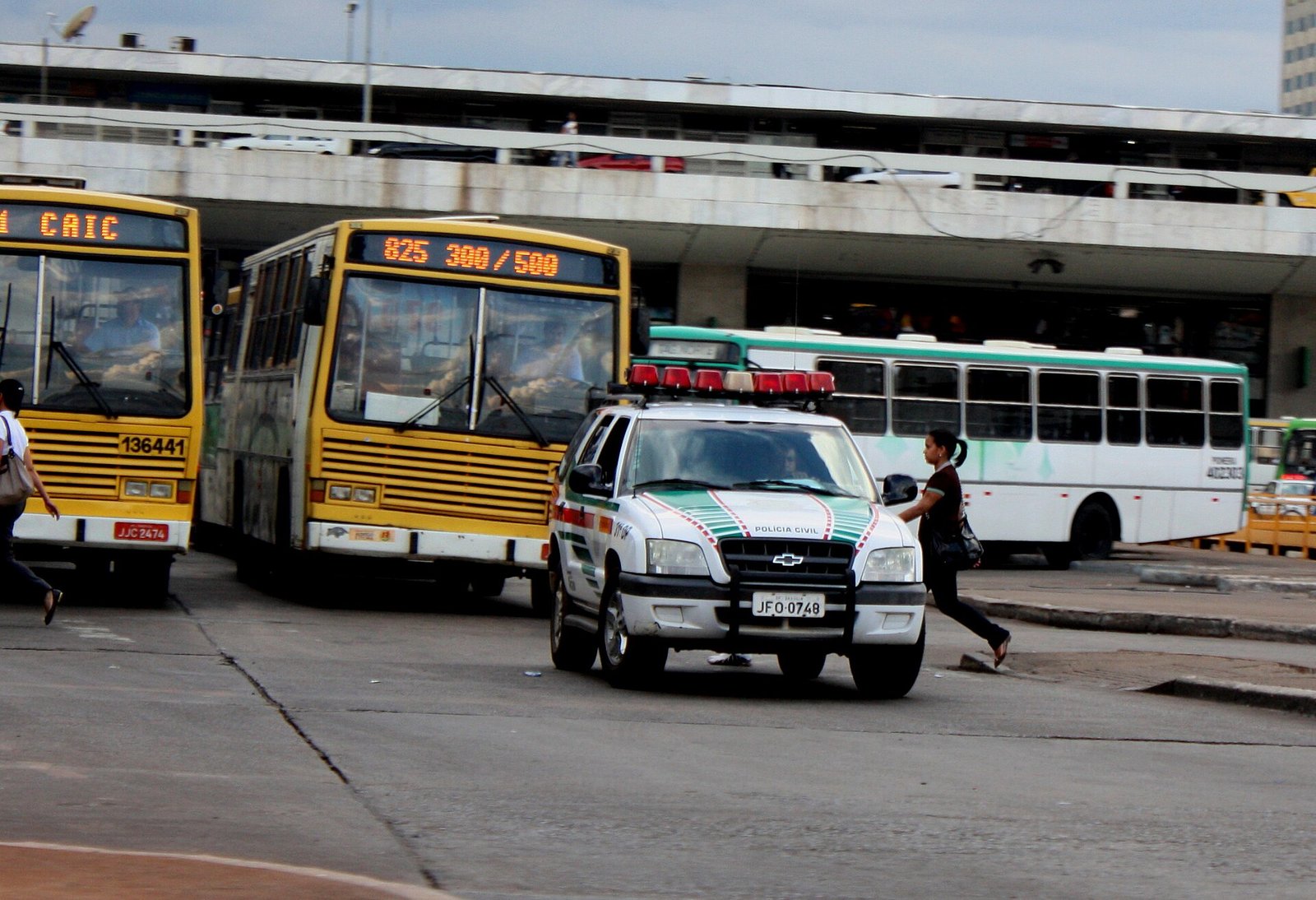 Viatura da Polícia Civil do Distrito Federal em via de Brasília, ao lado de ônibus do transporte público