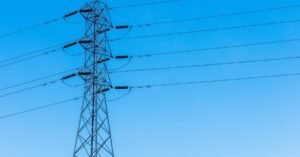 Torre de transmissão de energia elétrica com cabos sob céu azul