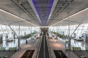 Saguão do Aeroporto de Brasília com esteira rolante central, poltronas e placas dos portões 19, 20 e 21