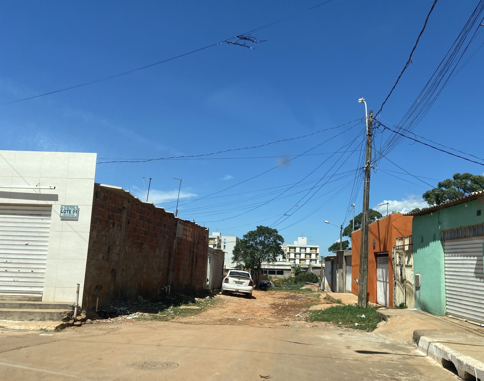 Rua de terra no Sol Nascente, no Distrito Federal, com lotes murados e casas em construção