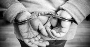 Mãos de homem algemadas atrás das costas