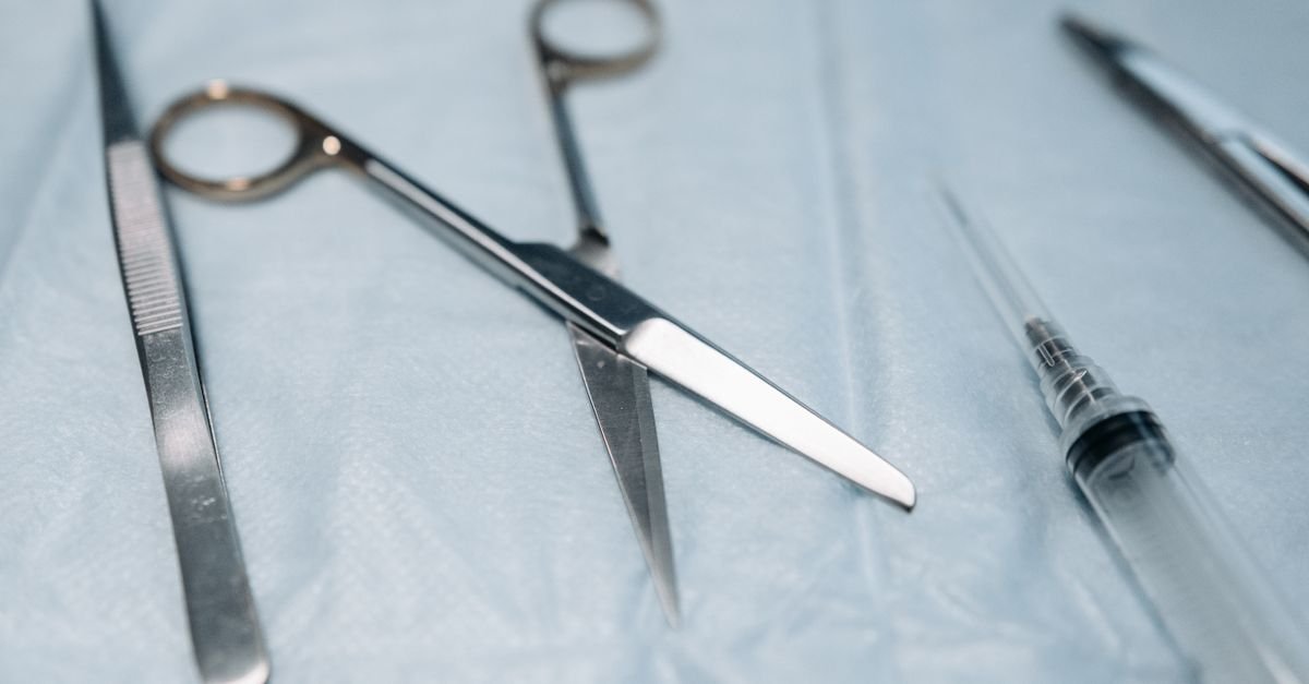 Instrumentos cirúrgicos de aço inoxidável sobre campo estéril azul em ambiente médico