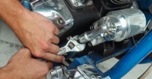 Maos de mecanico usando chave inglesa em motor de motocicleta
