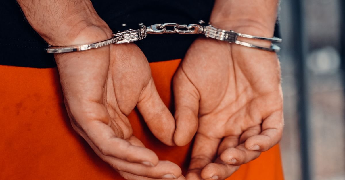 Mãos de homem algemadas atrás das costas durante abordagem policial